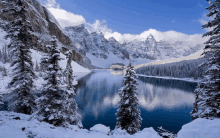 a snowy lake surrounded by snow covered trees and mountains