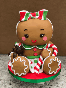 a gingerbread girl with a bow on her head is sitting on a cake