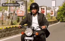 a man in a suit is riding a motorcycle down a road .