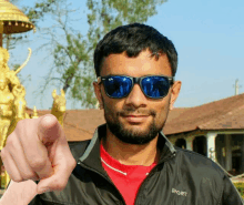 a man wearing sunglasses and a jacket that says sport on it