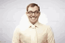 a man wearing glasses is making a funny face and smiling .