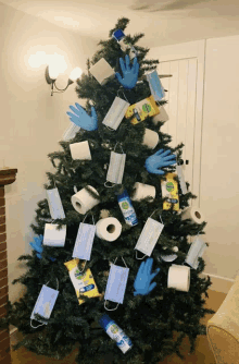 a christmas tree decorated with face masks gloves toilet paper and dettol wipes