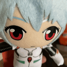 a close up of a stuffed toy with red eyes and a blue hair .