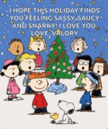 a group of peanuts characters singing in front of a christmas tree .