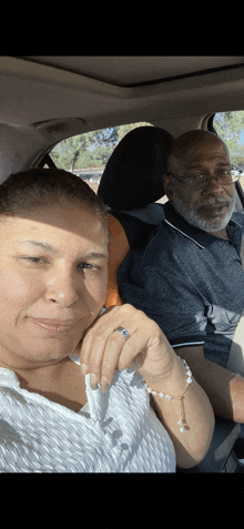 a man and a woman are sitting in a car and smiling