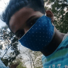 a man wearing a blue face mask is taking a picture of himself .