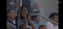 a woman sitting in a stadium with jiocinema written on the bottom right