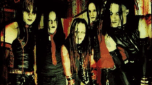 a group of people standing next to each other wearing black and red clothes