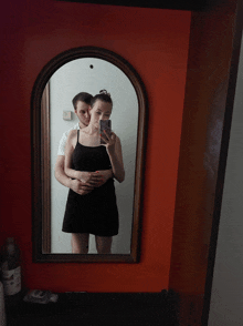 a man and a woman are taking a picture in a mirror