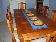 a table with four pies on it and a blue table runner