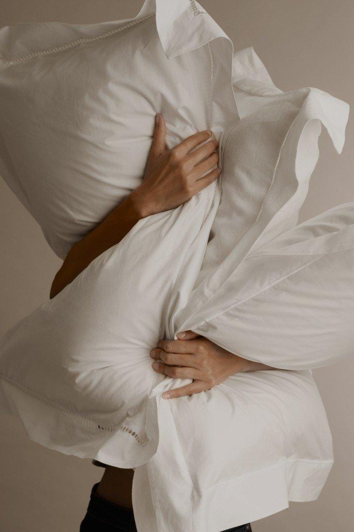 a person is holding a pillow over their head and face