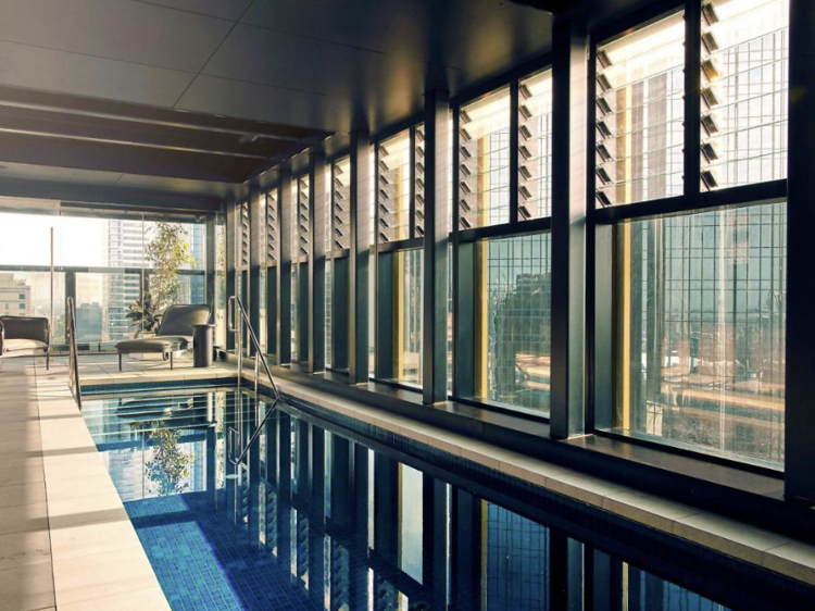 Indoor pool  with panelled floor to ceiling windows at the Quincy Hotel Melbourne. 