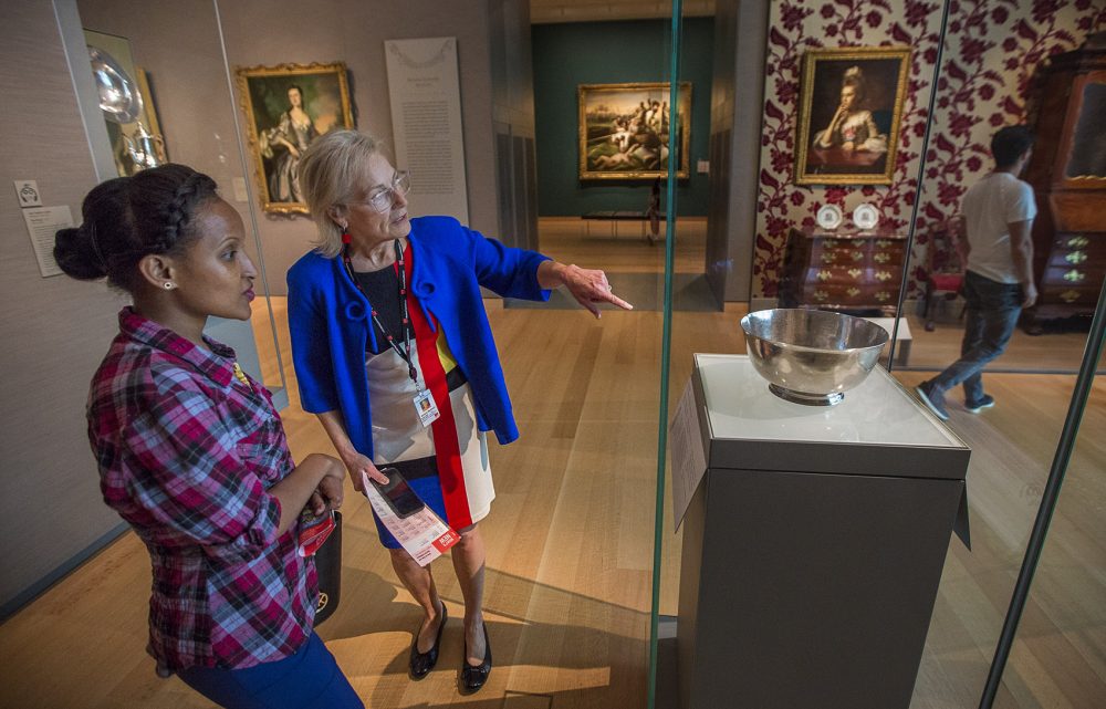 Dorene McCourt shows Hiwot Behabtu the Sons of Liberty Bowl at the MFA. (Jesse Costa/WBUR)