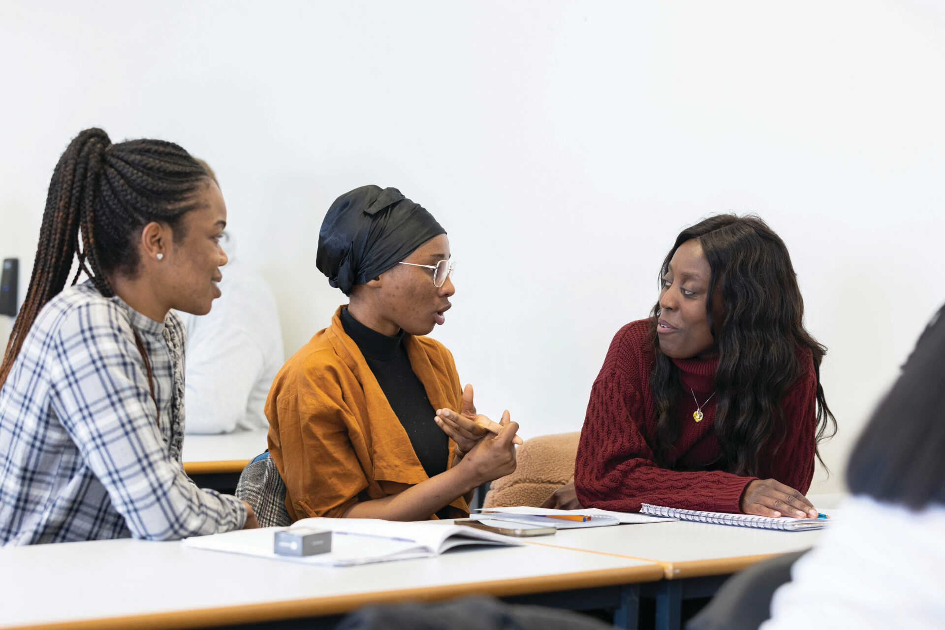 Three women talking while studying