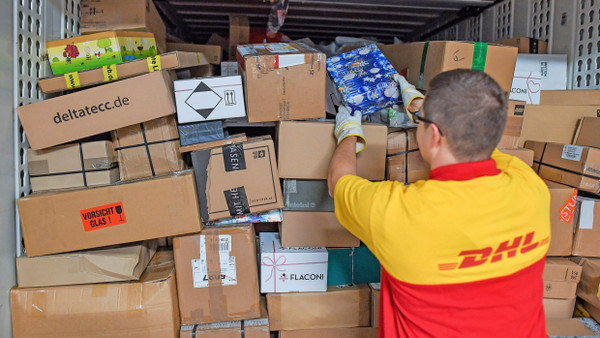 Alle Hände voll zu tun: Ein Mitarbeiter im DHL-Paketzentrum stapelt Sendungen in einen Lkw.