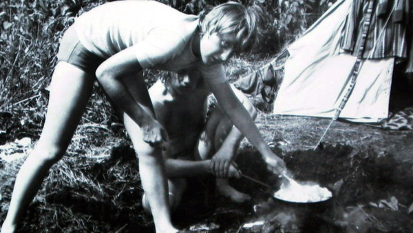 Angela Merkel bereitet im Juli 1973 nach ihrem Abitur mit Freunden beim Camping im brandenburgischen Himmelpfort (damals DDR) auf einer Feuerstelle ein Essen zu