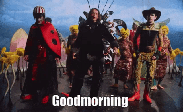 a group of people are standing in front of a sign that says goodmorning