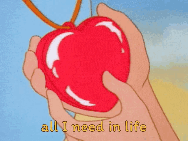 a cartoon of a person holding a red heart with the words all i need in life written below it .