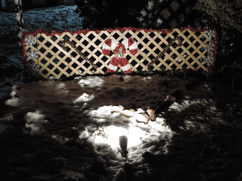 a wooden lattice fence with a candy cane decoration on it