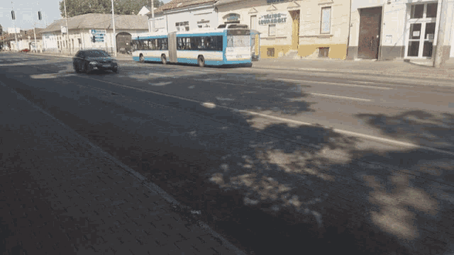 a blue and white bus is driving down a street in front of a building that has the word pharmacy on it