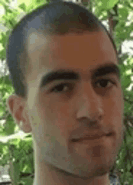 a close up of a man 's face with a shaved head .