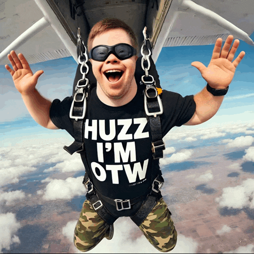 a man wearing a shirt that says huzz i 'm otw jumps out of an airplane