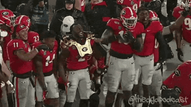 a group of football players are standing on a field and one of them is wearing a number 10 jersey .