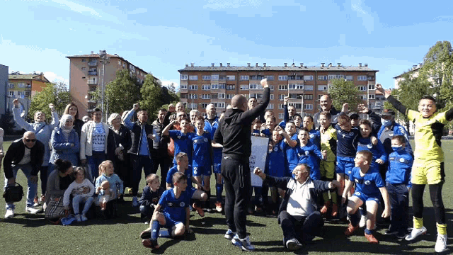 a group of soccer players are posing for a photo with a man holding a sign that says ' a '