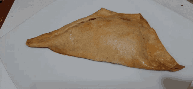 a close up of a triangle shaped pastry on a table