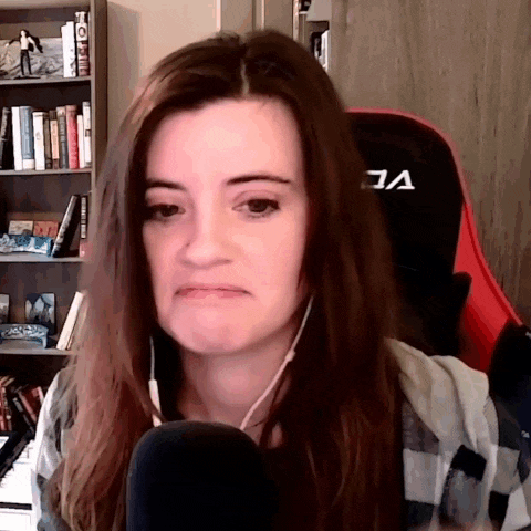 a woman wearing headphones is sitting in front of a microphone in front of a bookshelf with books on it .