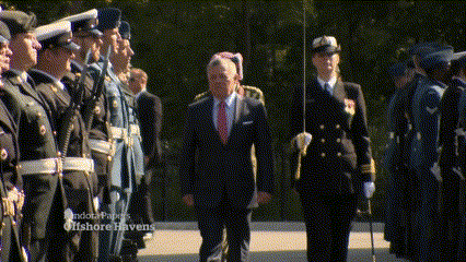 a man in a suit stands in front of a group of soldiers with the words offshore havens on the bottom left