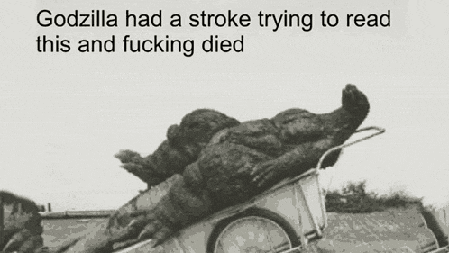 a black and white photo of a monster in a wheelbarrow with the caption godzilla had a stroke trying to read this