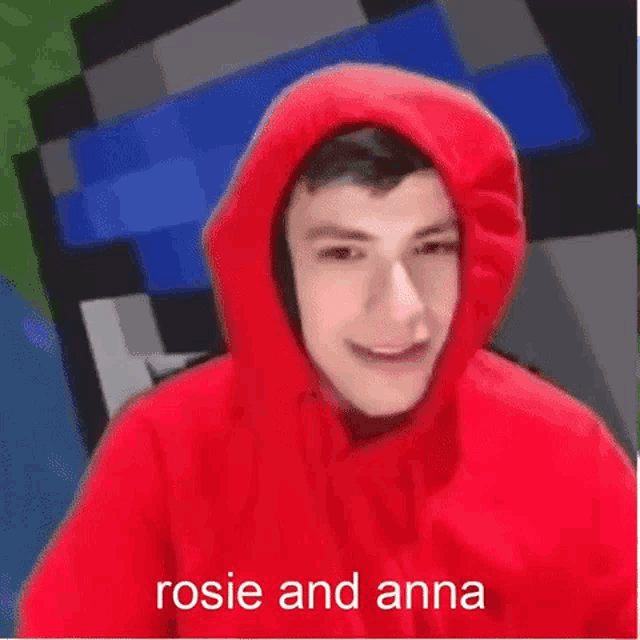 a young man wearing a red hoodie with the words rosie and anna written on it is smiling .