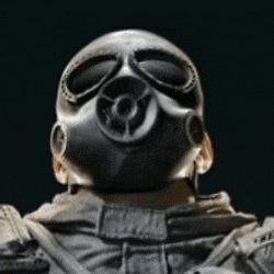 a man wearing a gas mask and goggles is looking up at the camera .