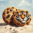 two chocolate chip cookies with a tiger face painted on them are sitting on top of each other on a sandy beach .