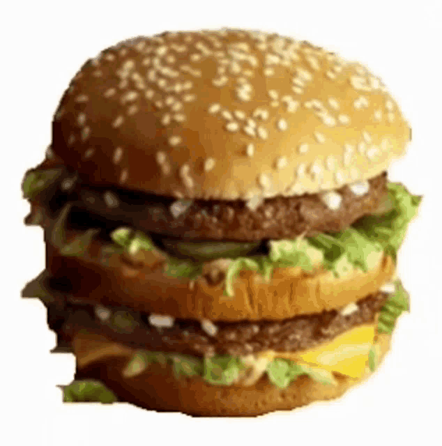 a hamburger with lettuce cheese and onions on a bun with sesame seeds