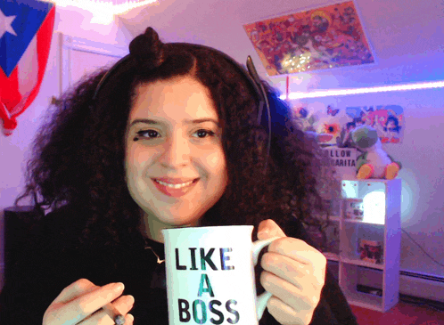 a woman is holding a coffee mug that says like a boss