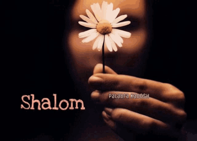 a woman is holding a flower with the word shalom in the corner