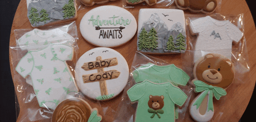 a cookie that says adventure awaits sits on a table