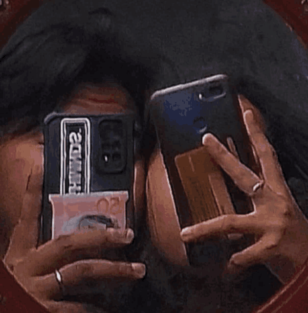 a person is taking a picture of themselves in a mirror while holding a cell phone with a case that says hmmd