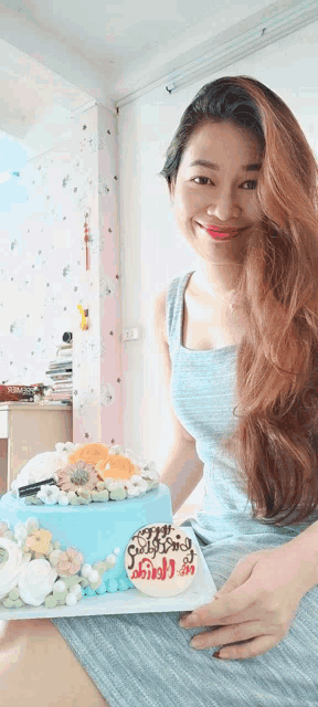 a woman is holding a birthday cake that says happy birthday