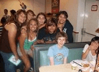 a group of people are posing for a picture in a restaurant .