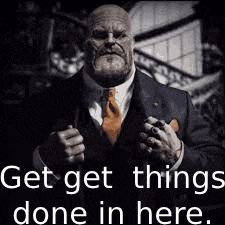 a man in a suit and tie is holding a gun with the words `` get things done in here '' .