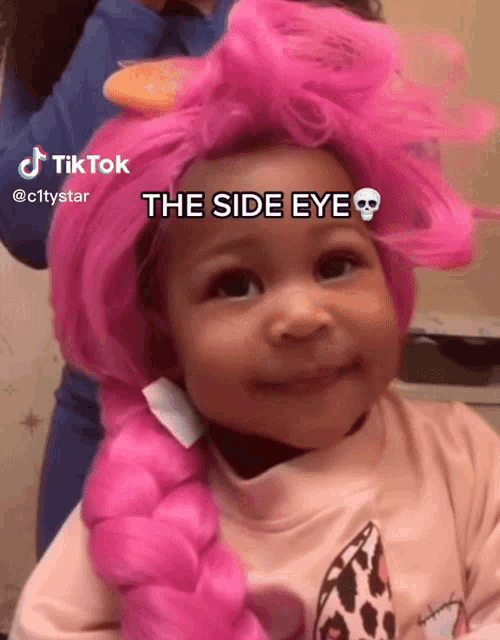 a little girl wearing a pink wig has a skull on her forehead