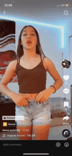 a girl in a brown tank top and blue shorts is on a tiktok video