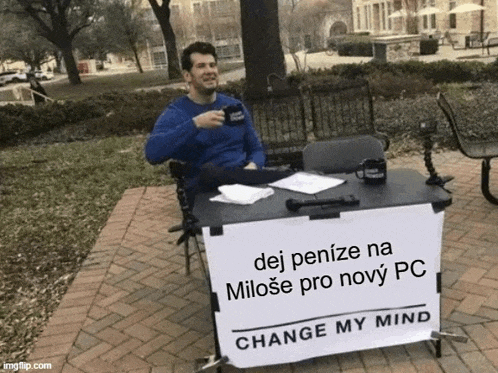 a man sits at a table with a sign that says change my mind on it