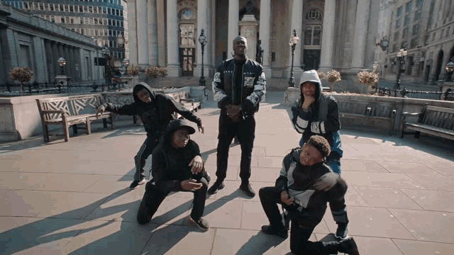 a group of young men are posing for a picture in front of a building with the letter a on it