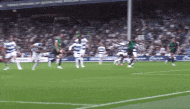 a group of soccer players are playing on a field with a sign that says ' sponsors of queens park '