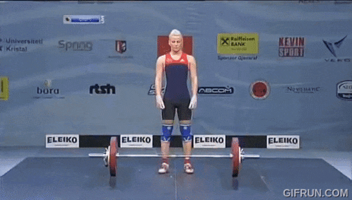 a woman is lifting a barbell in front of a wall with sponsor logos such as eleiko and kevin sport