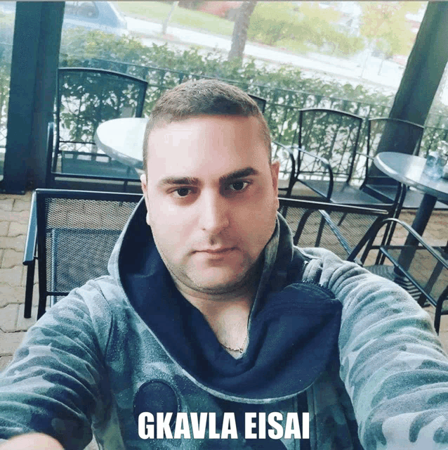 a man taking a selfie with the words gkavla eisai above him